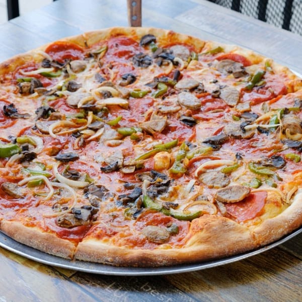 A whole Rusty Onion pizza with pepperoni, sausage, mushrooms, onions, and green peppers.