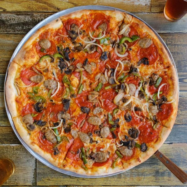 A whole Rusty Onion pizza with pepperoni, sausage, mushrooms, onions, and green peppers.